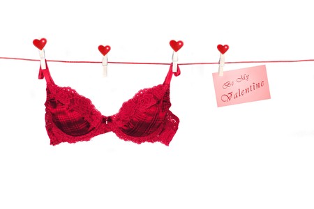 Fancy red Bra hanging from Clothes-Line with white backgroundの写真素材