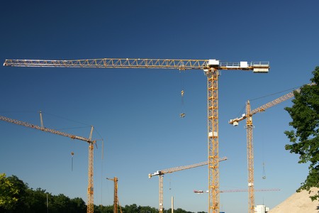 Many construction cranes on building site