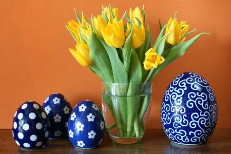 Fresh yellow tulips and blue ceramic easter eggs 