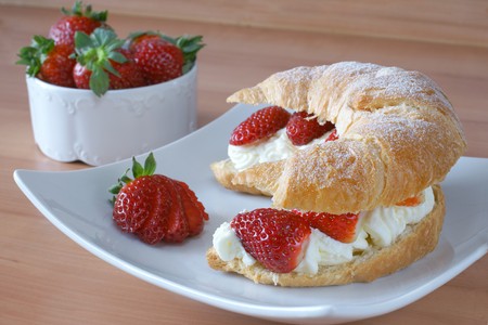 Fresh croissant stuffed with cream and fresh strawberryの写真素材