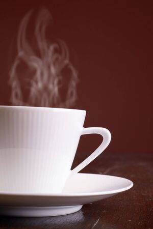 Cup of steaming hot coffee over dark background.の写真素材