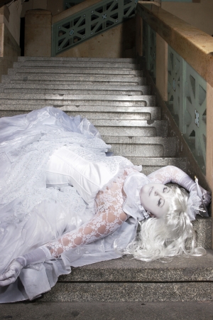 Beautiful princess all in white with a little crown laying の写真素材