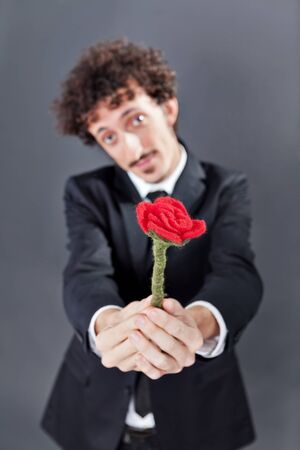 Boy with jacket is donating a fabric red rose
の写真素材