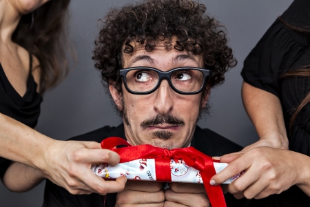 two girl disputing one present from a single boyの写真素材