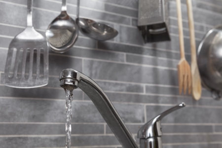 Kitchen faucet with dropping water and kitchen toolsの写真素材