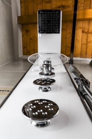 perspective from the bottom of a modern shower in a bathroom with a wooden ceilingの写真素材