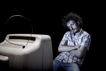 a man is getting bored while watching tv aloneの写真素材