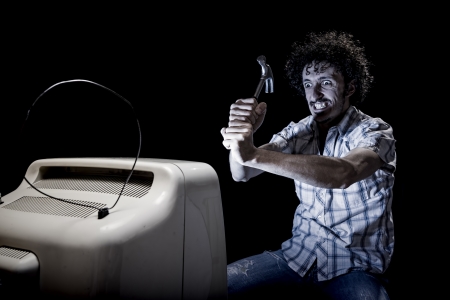 crazy man is crashing tv with a hammerの写真素材
