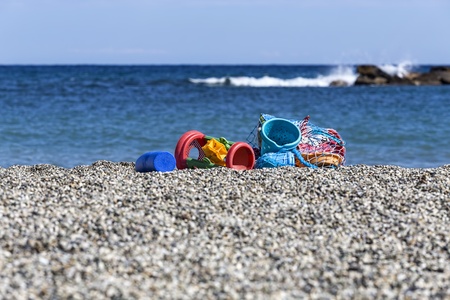 Some beach toys abandoned in a net on the sea shore の写真素材