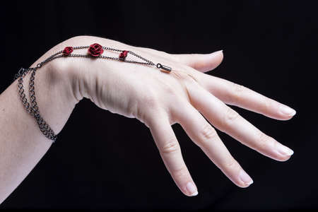 Female hand, isolated on black background, is wearing some ornamentsの写真素材