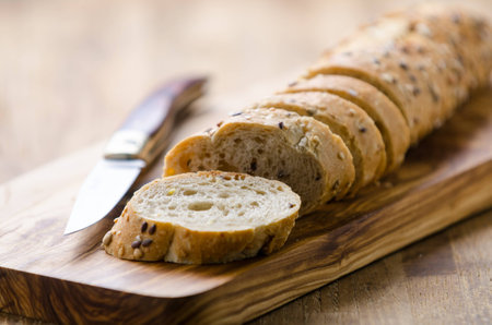 bread with seeds on a wooden board and knife