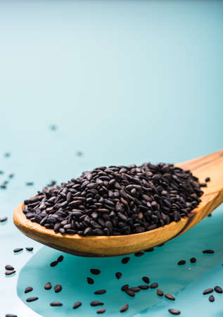 black sesame seeds on a olive wood spoonの写真素材