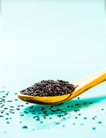 black sesame seeds on a olive wood spoonの写真素材