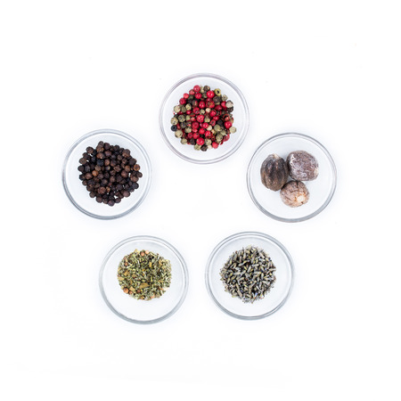 five different kind of dry spices on glass cups from above
