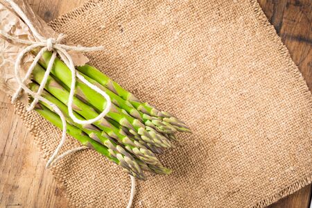 bunch of fresh asparagus on a wooden tableの写真素材