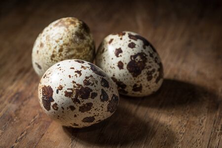 three quail eggs isolated on tableの写真素材