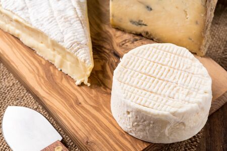 wooden board with cheeses and knifeの写真素材