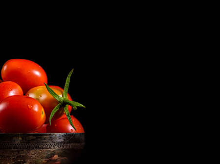 tomato in a silver cup with black copyspace on rightの写真素材