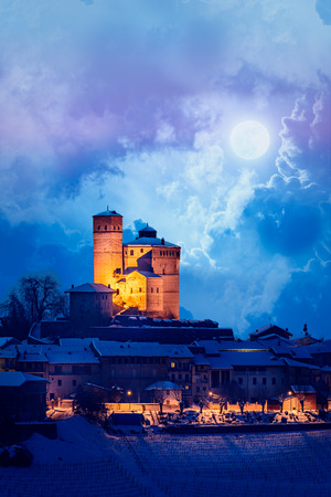 Serralunga castle during a winter night with moon and snow in langhe region, Italyの写真素材