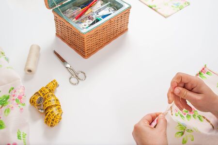 hands of young woman sewing