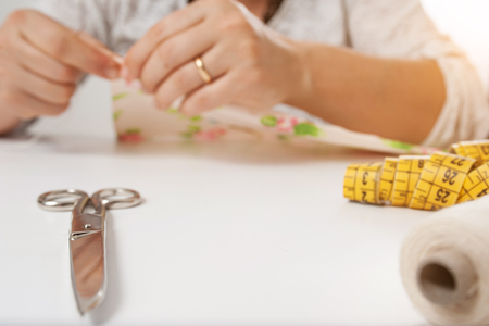 hands of young woman sewing