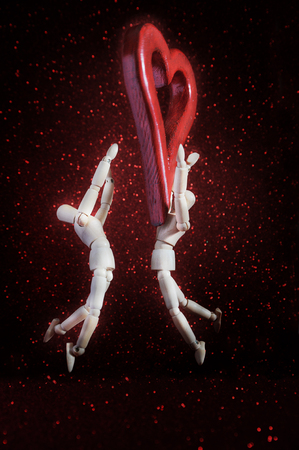 mannequins in love, playing with a wooden heartの写真素材