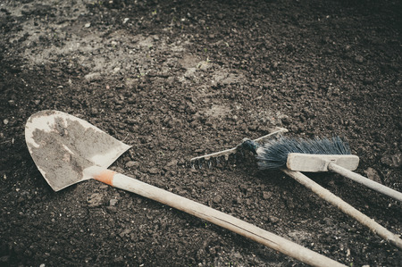 broom rake and shovel resting on the groundの写真素材