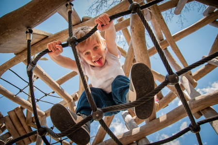 baby plays and has fun climbing, playing with ropesの写真素材