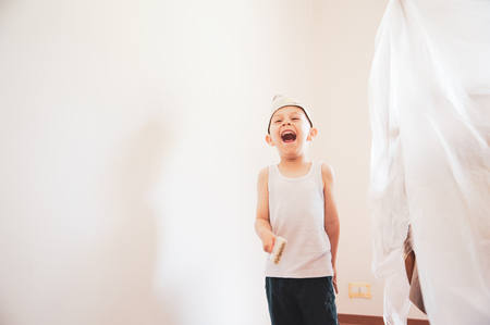 child painter paints walls with paper hatの写真素材