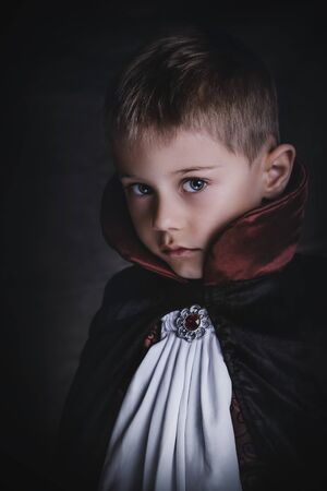 charming baby dressed as a vampire in a dark atmosphere, with gothic  and elegance clothesの写真素材
