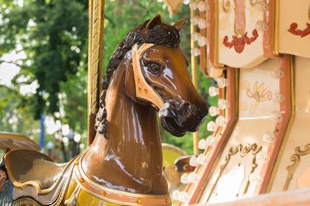 a brown horse of a carousel in a parkの写真素材