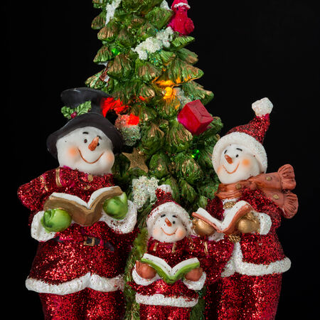 Three snowman in santa claus dress with treeの写真素材