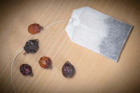 Dry Rosehip fruit for healty tisane and pocket tea on woodの写真素材