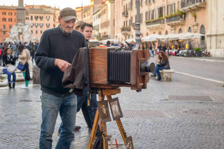 Rome, Italy - March 28, 2015: a man takes pictures to tourists with an old camera in Navona squareのeditorial素材