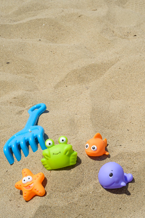 funny and colorful plastic toys on the beachの写真素材