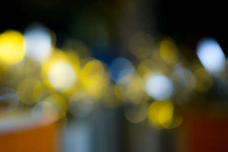 Abstract Blurry Christmas lights, yellow and blue on dark backgroundの写真素材