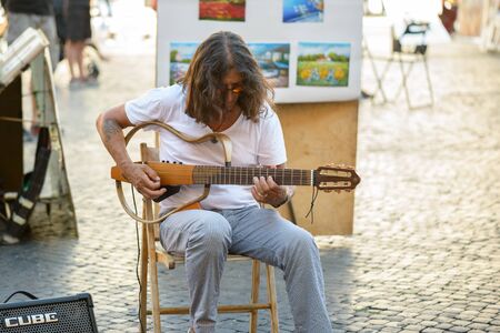 Rome, Italy - August 22, 2015: the famous Navona square a street artist  man playing guitar