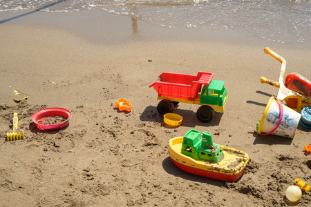 colorful plastic toys on the beach, boat, truck and so onの写真素材