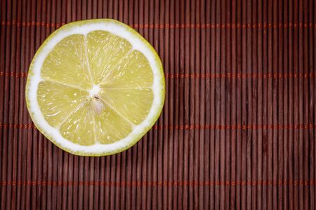 Fresh lemon on a nice wicker carpet as backgroundの写真素材