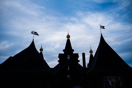 A wooden ukrainian church silhouette during the sunset