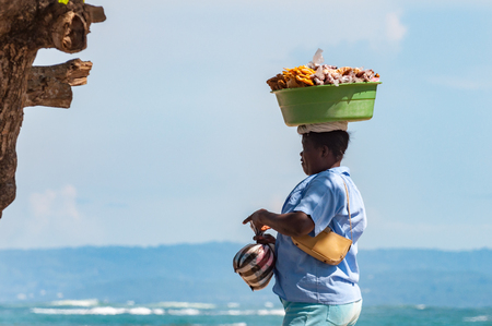 Puerto Plata, Dominican Republic - October 03, 2010: A woman selling fruits on the Santo Domingo beachのeditorial素材
