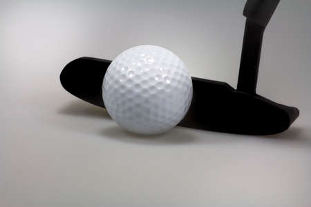 Image of a golf ball with a putter on a gray 