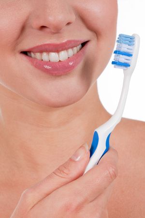 Close-up of a yougn woman smile with toothbrush, isolated on whiteの写真素材