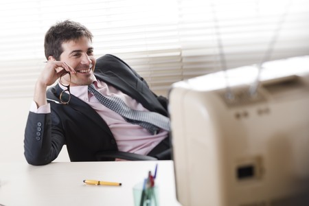 Buinessman watching a stylish retro TV, selective focusの写真素材