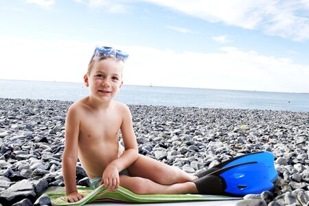 Cute toddler boy with diving mask and flippers at the beach; lot of copy-spaceの写真素材