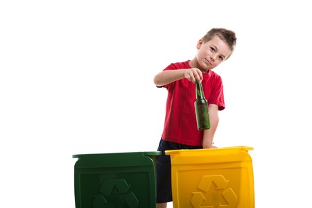 Little boy throwing botlles into recycling binの写真素材