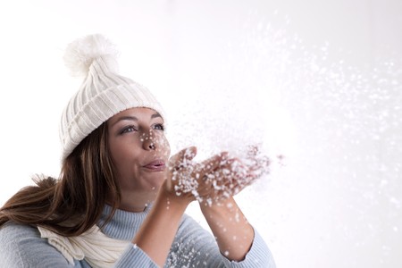 Beautiful woman blowing powder snowの写真素材