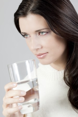 Portrait of a young woman drinking a glass of water.