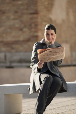 Young businesswoman taking a rest with newspaperの写真素材