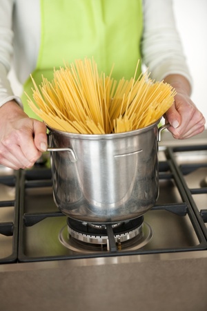Woman Preparing Spaghetti In Pot, close-upの写真素材